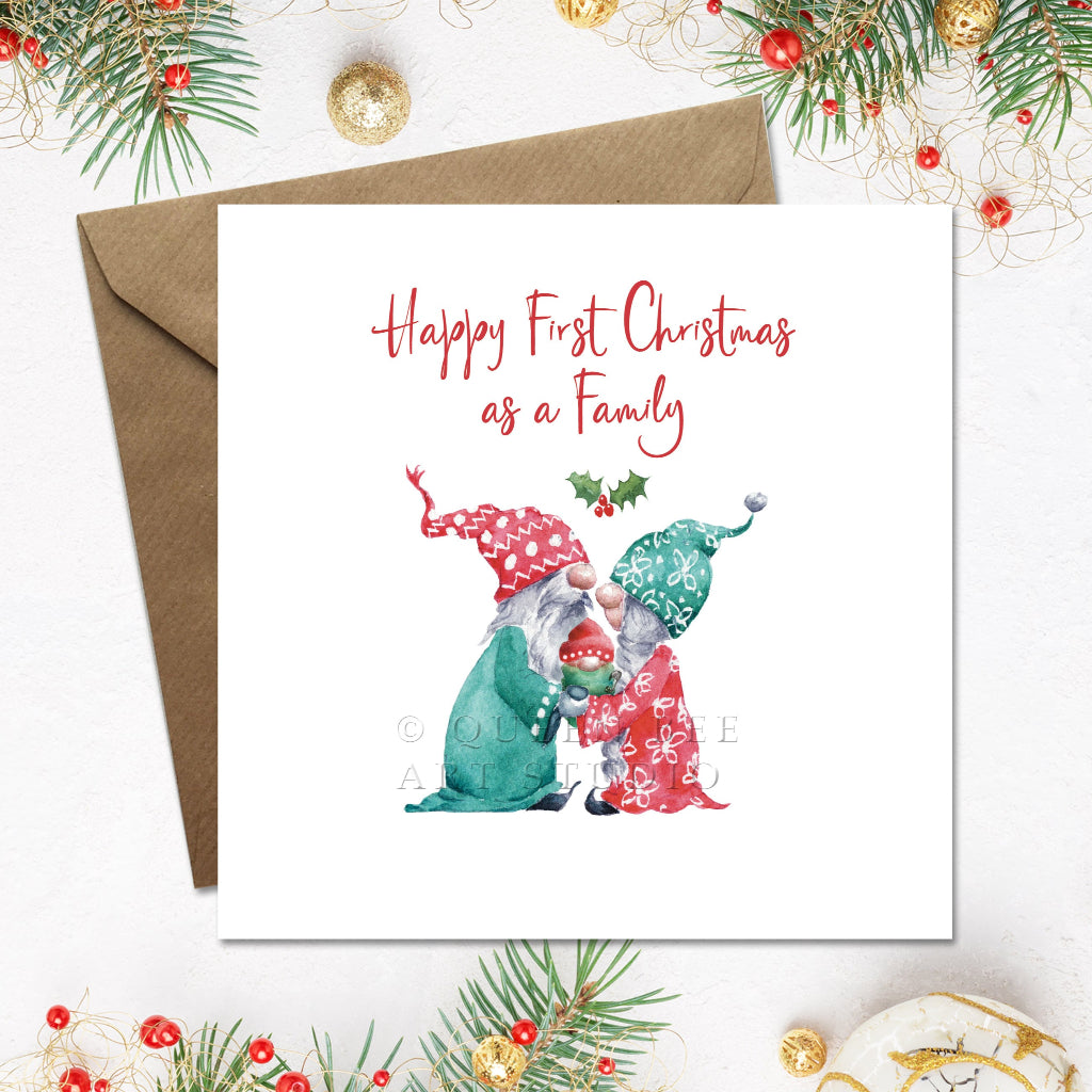 Christmas card with two gnomes and 'Happy First Christmas as a Family' text on a white background with festive decorations.