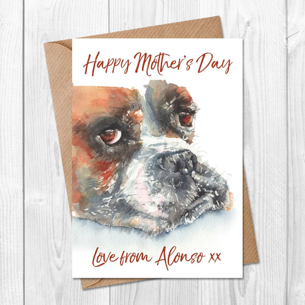 Personalised Mother's Day card with a cute boxer dog illustration and 'Happy Mother's Day' text on a wooden surface. Printed with 'love from the dog's name' along the bottom