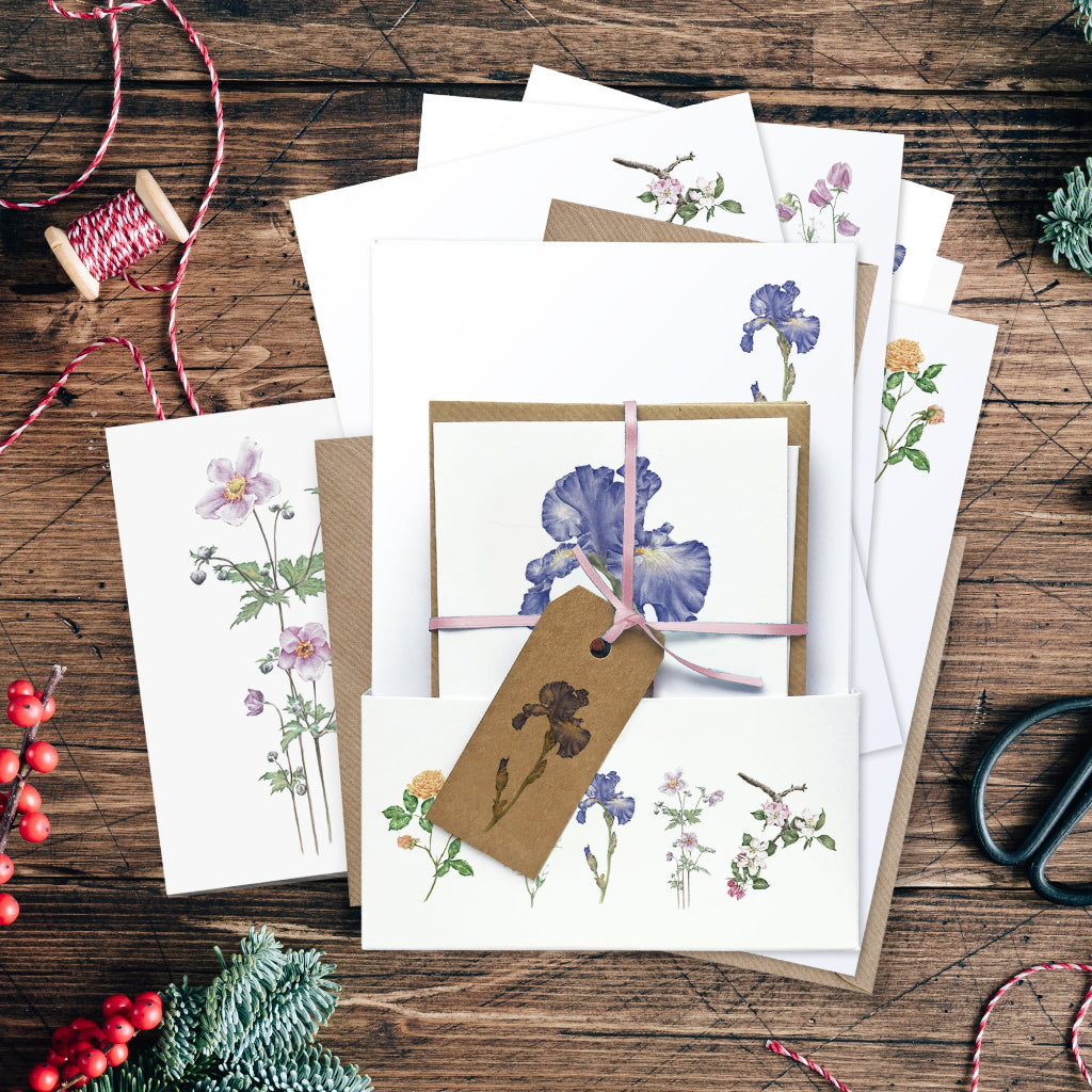 Pretty stationery set printed with different flowers, showing floral writing paper, cards, envelopes, gift tag and ribbon, suitable for Christmas present
