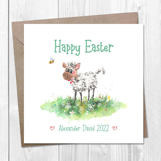 Personalised Easter card with an illustration of a baby lamb surrounded by flowers and a bee, with the text 'Happy Easter' and a name on the front. The card is accompanied by a brown Kraft envelope.
