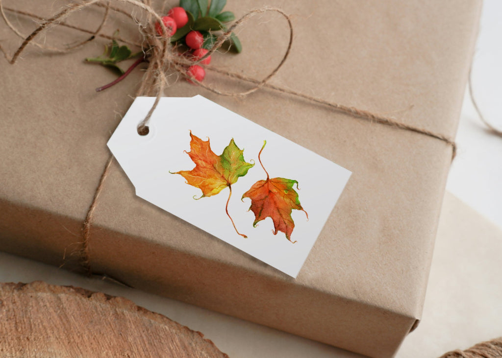 Gift wrapped in brown paper with a leaf-themed tag on a wooden surface