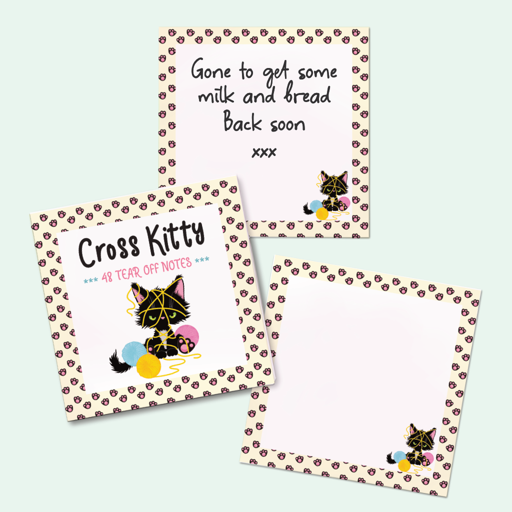 A note book and pages with decorative pastel yellow borders with paw prints and a cute black kitten cartoon, arranged on a pale mint background. 