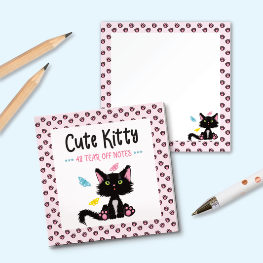 A square tear-off note pad  with a cute black kitten illustration and pink patterned borders, styled on a light blue background with two wooden pencils and a white pen. An example page with a smallet cat illustration and pink paw print pattern is shown
