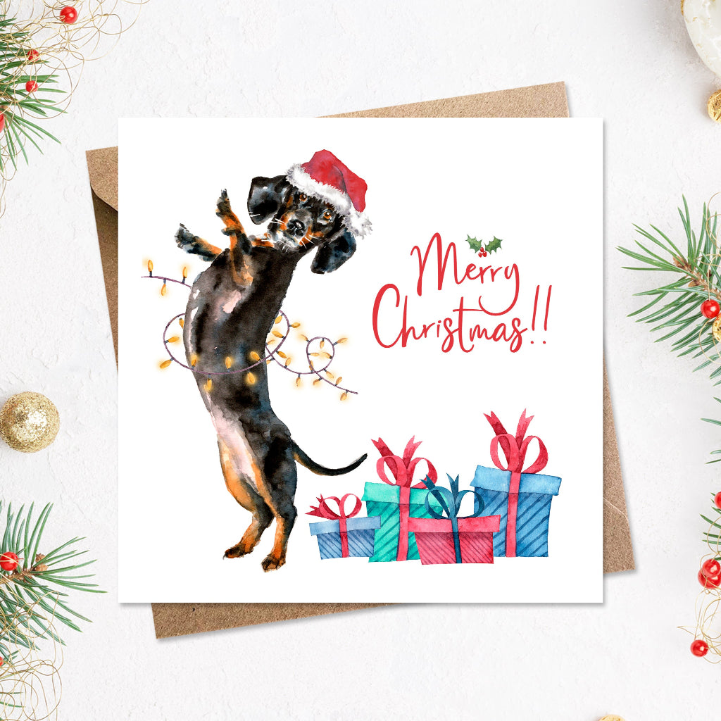 Large square merry christmas card with a funny black & tan short haired german dachshund printed on the front