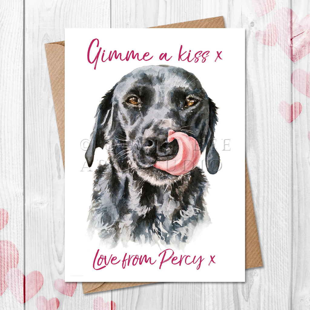 Personalised Valentine's card with a black labrador illustration from the dog and text on a wooden surface with heart patterns.