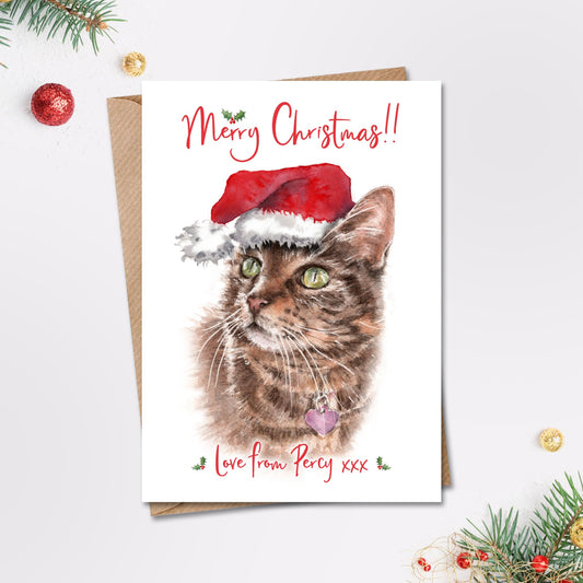 Personalised merry christmas card with a painting of a short haired tabby cat in a santa hat on the front.