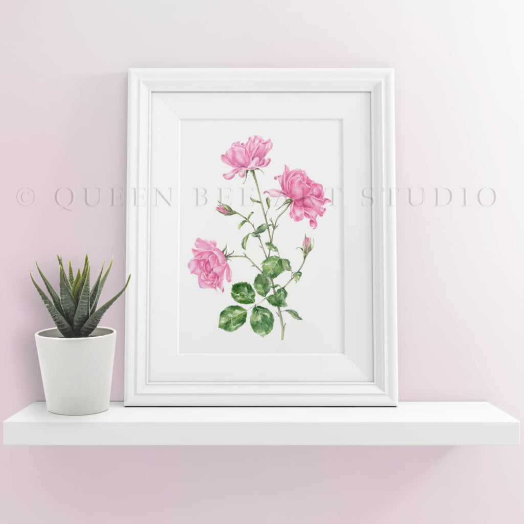 small framed print of pale pink roses on a white shelf in modern room setting