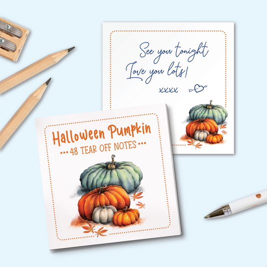 A set of Halloween-themed tear-off notes displayed on a light blue background with wooden pencils and a white pen. The front note features orange text reading 'Halloween Pumpkin' and '48 TEAR OFF NOTES' above an illustration of green, orange, and white pumpkins.