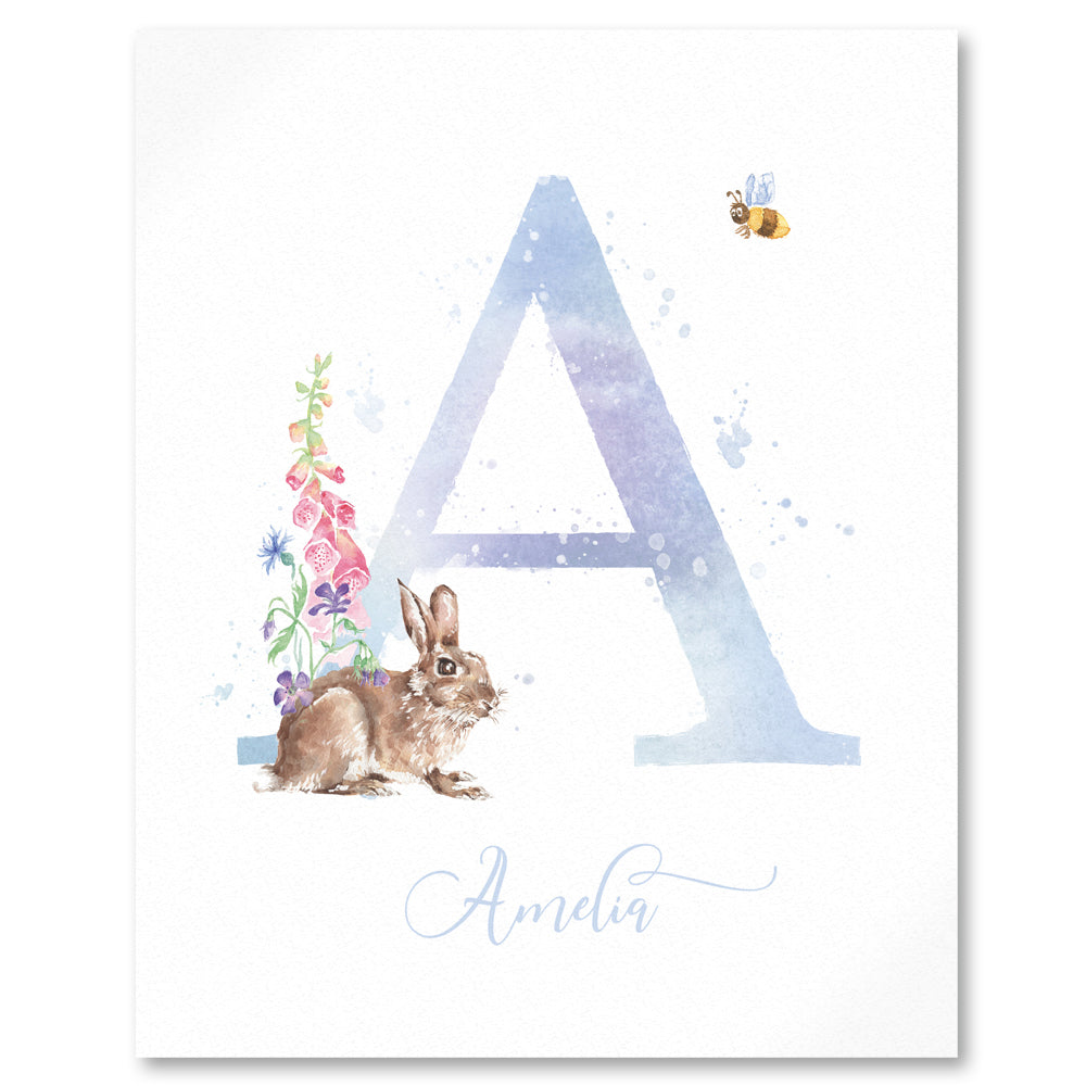 Close up of monogram print in blue lilac personalised with girls name, with small brown rabbit, pink foxgloves and flowers