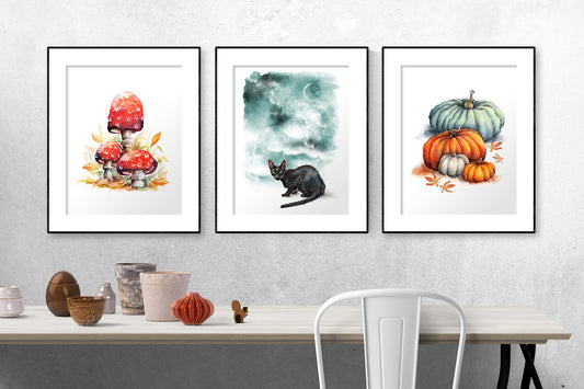 set of 3 framed halloween prints in gallery wall setting, with red toadstool, fantasy black cat & night sky and pumpkins